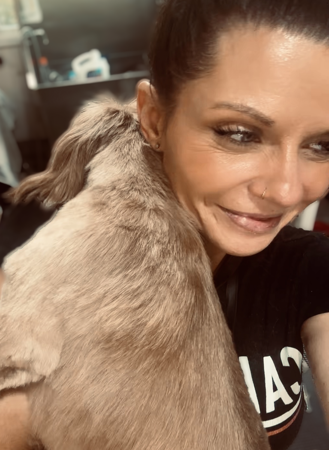 Amber sharing a quiet moment with a pup in the grooming studio